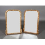 A PAIR OF VICTORIAN GILTWOOD MIRRORS OF ARCHED FORM, the plain plates within broad lozenge and