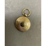 A Victorian locket engine turned in 9ct gold within a circular outline with glazed interior, push