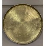 A circular brass tray, finely engraved with bands of text, animals, insects and figures, 73cm