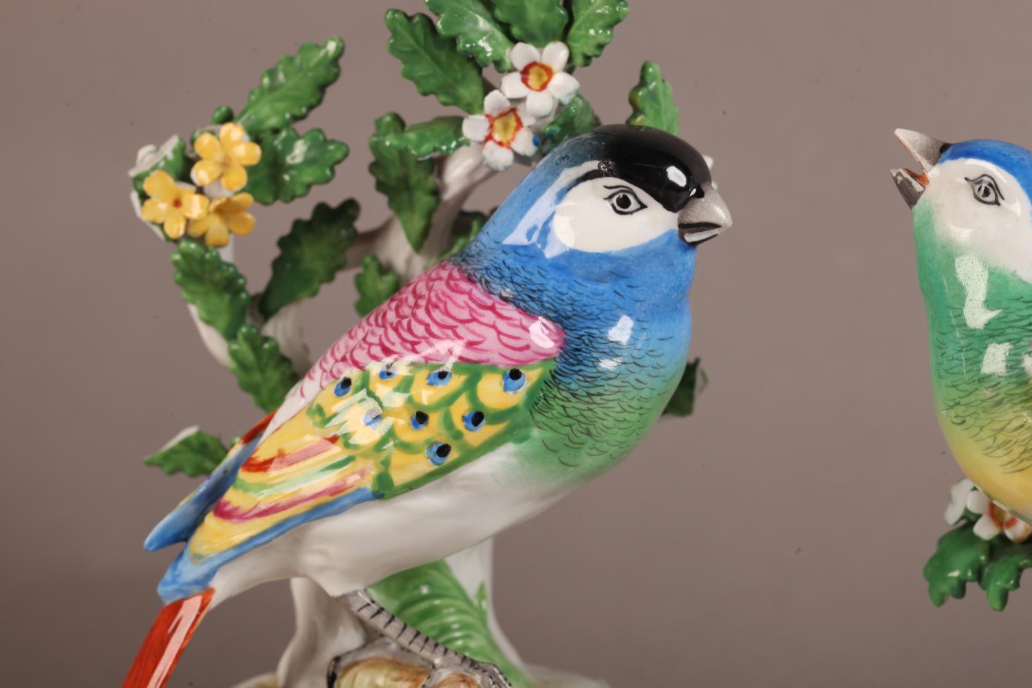 A pair of Continental porcelain figures modelled as a pair of colourful songbirds before leaf and - Image 2 of 4