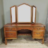 A reproduction cherry veneered dressing table with triptych bevelled mirror back, the base with