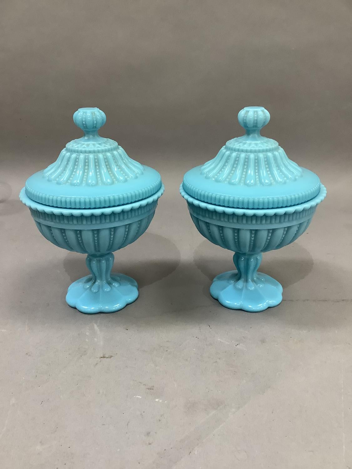 A pair of Victorian turquoise glass pedestal cups and covers, fluted and bead decorated with