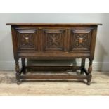 A reproduction oak cabinet on stand, the hinged lid above a front with three raised fielded panels