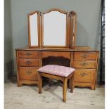 A reproduction cherry wood veneered dressing table with triptych bevelled mirror back, the shaped