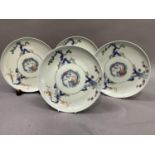 A set of four Japanese porcelain plates, each decorated to the centre with a stylised dragon, the