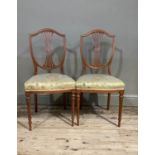 A pair of boxwood inlaid shield back chairs in Hepplewhite style, the camel backs above waisted