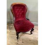 A Victorian mahogany framed nursing chair, foliate and moulded with buttoned back and stuffed