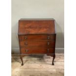 A reproduction mahogany bureau in George III style outlined with ebonized stringing, the fall-flap
