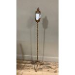 A gold painted wrought iron standard lamp with fluted opaque white glass shade contained within a