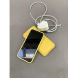 An i-phone in yellow case, yellow wallet with charging lead