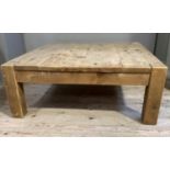 A large pine coffee table with planked top and square legs, 118cm square