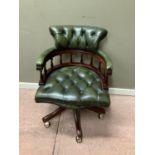 A reproduction captain's style desk chair with buttoned green leather upholstery, 87cm high