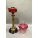 A Victorian brass Corinthian column lamp with cranberry reservoir, acid etched cranberry to a pale