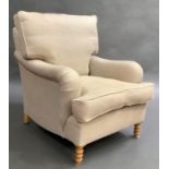 An upholstered armchair in oatmeal fabric on turned legs