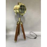 A reproduction brass and mahogany stained movie search light on adjustable legs, the cylindrical