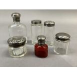 Five various silver lidded glass toilet jars and a ruby glass salts bottle with silver lid