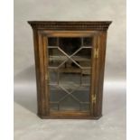 An oak hanging corner cupboard in George III style, flared cornice and dentil moulded frieze above