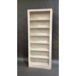 A white painted open book case with fixed shelves, 220cm high, 89cm wide