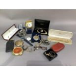 Two pocket flasks, a travel clock, powder compacts, purse with Crowns, Half Crowns and other