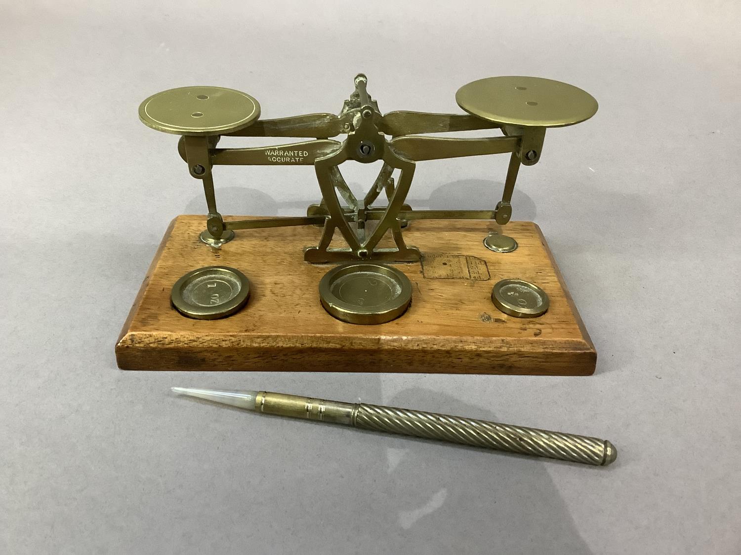 An Edwardian mahogany and brass set of postal scales with weights for 0.5oz, 1oz and 2oz together