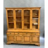 A cherry bookcase in George III style with flared cavetto cornice above four glazed doors, the