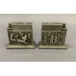 A pair of gas table lighters by Myflam each with chased reliefs of 17th century Dutch scenes,
