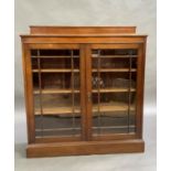A mahogany glazed bookcase with shallow upstand, the pair of doors with moulded glazing bars, on