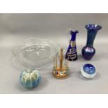 A quantity of decorative glassware including two paperweights, an iridescent blue glass vase, a gilt