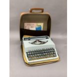 An Imperial blue plastic typewriter, serial no.SP883P, contained within a tan case with guarantee