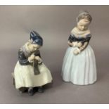 Two Royal Copenhagen figures of Dutch girls, one standing, the other sitting knitting, printed and