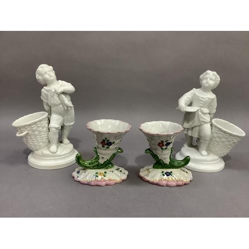 A pair of continental porcelain figures, fisherboys, each standing beside an open basket, 18cm high; - Image 2 of 2