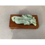 A Chinese carved jade flower head and toad together with a hard wood stand, 13cm long by 6cm wide