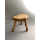An ash and oak stool of irregular rectangular form on three turned legs, 32cm wide max