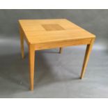 A modern oak extending kitchen table with rounded square top when closed, on moulded square