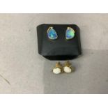 A pair of opal doublet and diamond ear studs each collect set with a tri-foil oval opal and small