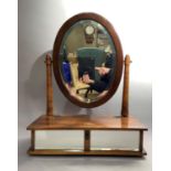 A reproduction stained beech dressing table mirror, the beveled oval plate on pair of turned