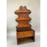 An early 20th century oak spoon rack, the shaped back with three rows of racks above and open box