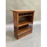 An Edwardian mahogany cabinet, the rectangular top with rear hinged flap, the front with fret