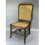 A mahogany stained beech bedroom chair with caned back and seat, turned splayed legs joined by