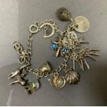 A curb link bracelet in silver hung with approximately twelve charms, total approximate weight 33g,