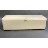 A Global Art House cream leather ottoman with bound edges, 140cm wide