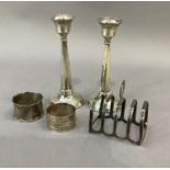A silver five bar individual toast rack, Birmingham 1934 together with two silver napkin rings and a