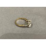 A single stone ring in 9ct gold claw set to the centre with a brilliant cut cubic zirconia flanked