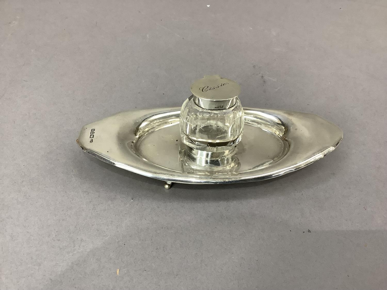 An Edward VII oval silver inkstand, the centre with collar fitted cut glass well with hinged