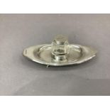 An Edward VII oval silver inkstand, the centre with collar fitted cut glass well with hinged