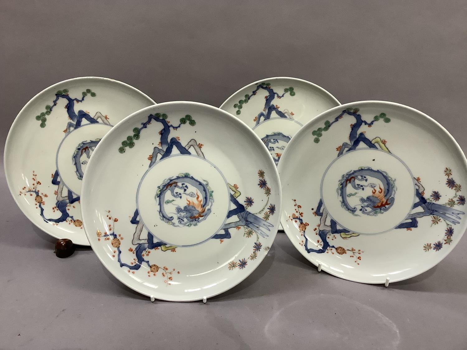 A set of four Japanese porcelain plates, each decorated to the centre with a stylised dragon, the - Image 2 of 6