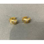 A pair of ear cuffs in white and yellow engine cut metal (test as 18ct gold), total approximate