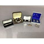 Two pairs of silver cufflinks together with a tie clip and two pairs of cufflinks in base metal