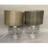 A pair of perspex table lamps with silvered satin shades