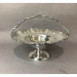 A continental white metal fruit basket of circular outline, fluted and floral embossed rim with cast